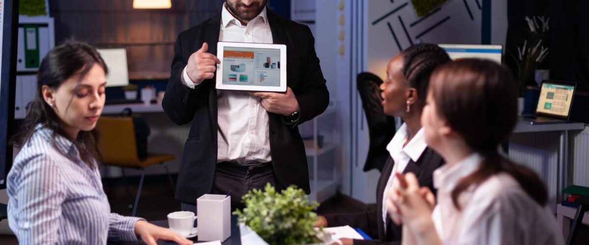 Focused businessman showing corporate graphs presentation using tablet working company ideas 1 1 1200x500